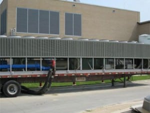 Trailer-mounted air-cooled rental chiller connected outside a building